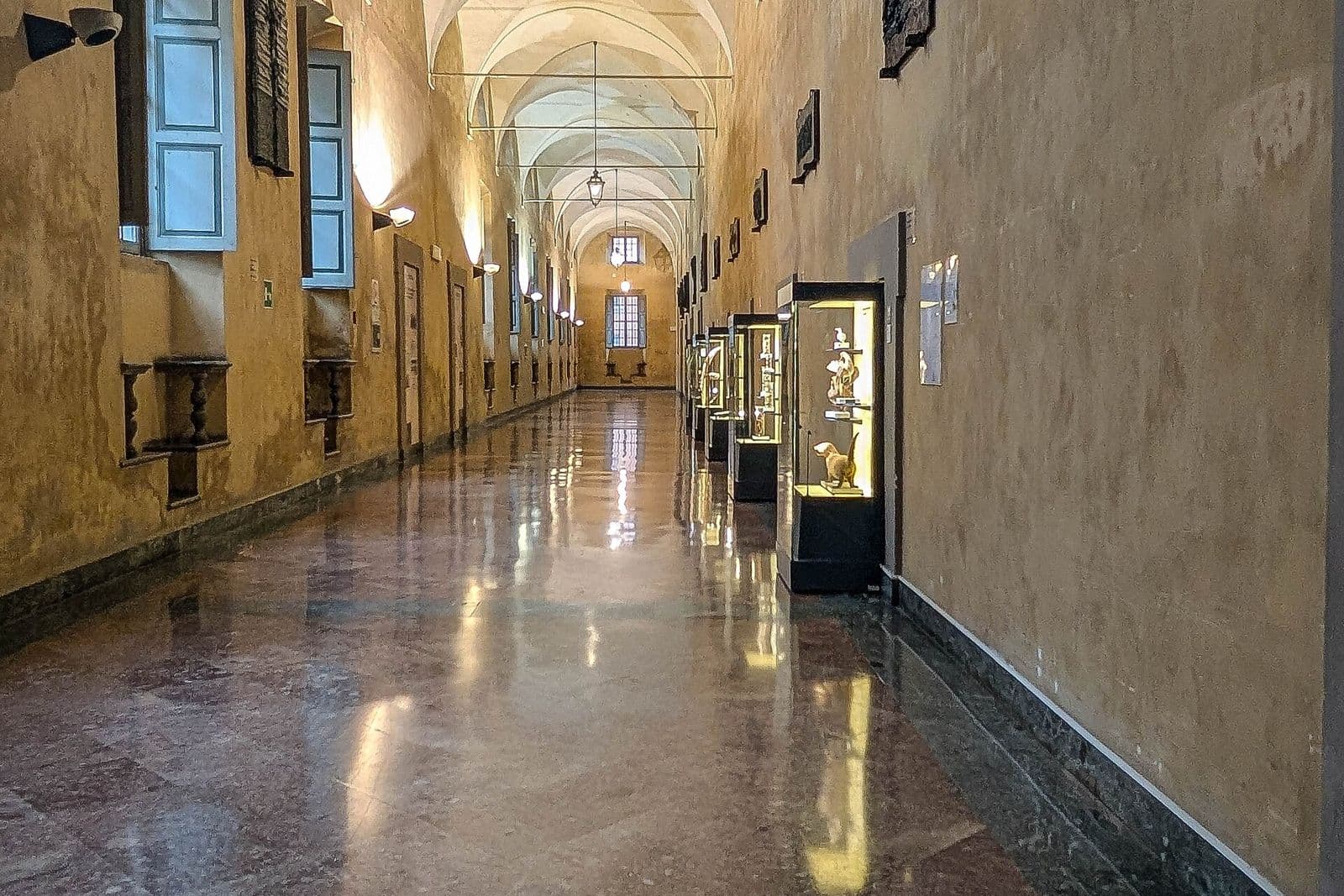 Il lungo corridoio con volte e pavimento lucido del Palazzo dell'Università di Parma
